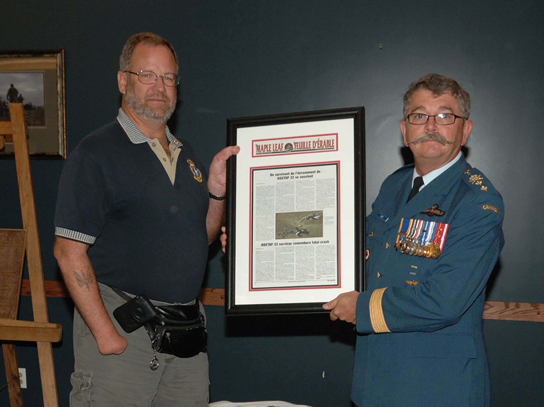 Pendant la cérémonie marquant le 50e anniversaire de la Station des Forces canadiennes (SFC) Alert, qui s’est tenue à la SFC Leitrim, en Ontario, en septembre 2008, le brigadier-général Anthony Hines présente au matelot-chef (à la retraite) Douglas N. Montgomery, survivant de l’écrasement du vol 22 de l’opération BOXTOP à la SFC Alert, le 30 octobre 1991, un article encadré publié dans La Feuille d’érable qui porte sur le récit de sa survie. PHOTO : Caporal-chef Serge Tremblay, SU2008-0508-10