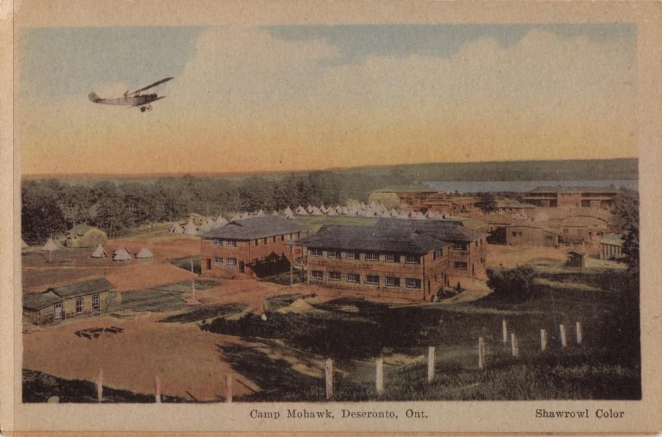 An undated postcard shows a Curtiss JN-4 “Canuck” trainer aircraft overflying Camp Mohawk, near Deseronto, Ontario, IMAGE: Deseronto Archives, https://deserontoarchives.wordpress.com