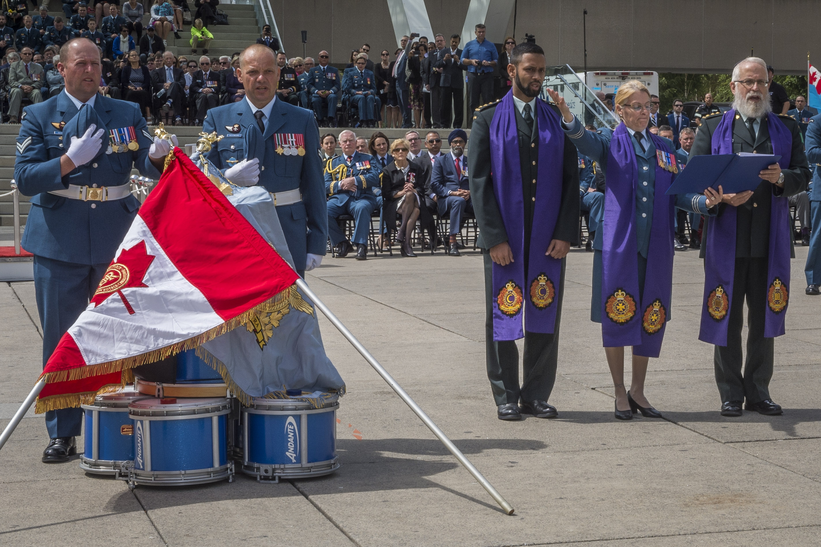The RCAF chaplain, Lieutenant-Colonel Martine Bélanger, accompanied by Imam Captain Ryan Carter (left) and Rabbi Captain Lazer Danzinger (right), consecrates the RCAF’s new Colours on September 1, 2017. Through this means, the Colours are sanctified and devoted to service as symbols of honour and duty. Further, all members of the Royal Canadian Air Force, through those on parade, rededicate themselves to the ideals the Colours represent. PHOTO: Corporal Alana Morin, FA03-2017-0114-001