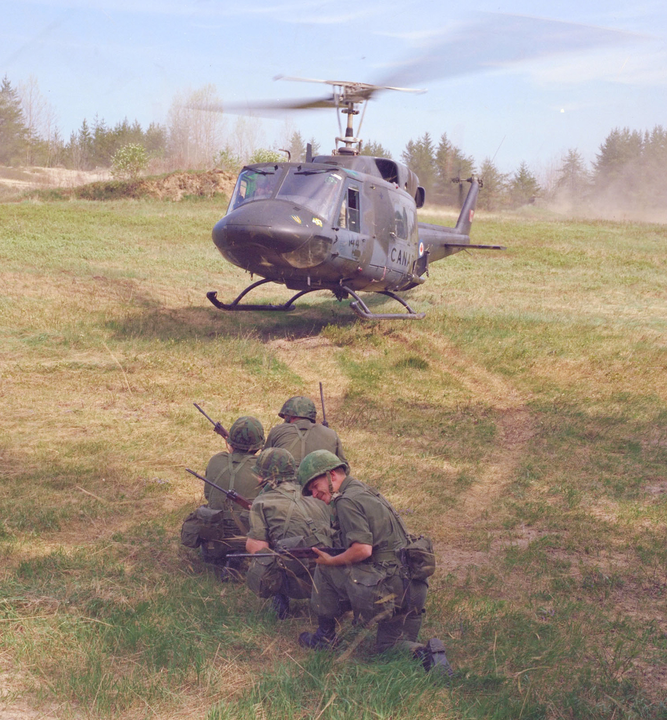 Four soldiers wait for an airlift by a CH-135 Twin Huey helicopter during a training event supported by 427 Squadron around 1982. An important part of 427 Squadron’s celebrated history of aviation excellence, the CH-135 Twin Huey helicopter served Army bases across Canada and was frequently used on United Nations missions around the world. 427 Squadron retired the CH-135 Twin Huey in 1997, after receiving the last of the newly-purchased Bell CH-146 Griffon fleet.  PHOTO: DND Archives, ISC82-977