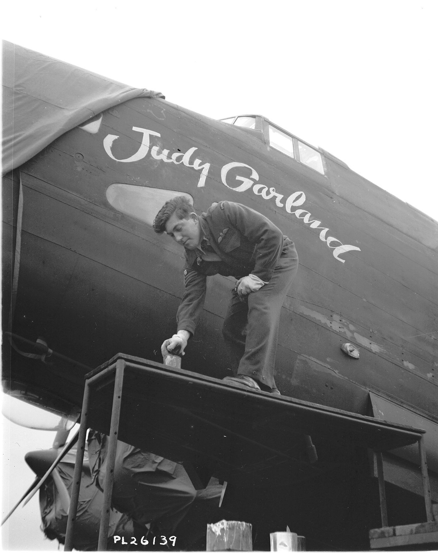 On November 16, 1943, Flight Sergeant J. Mawson of Kingston, Ontario paints a design displaying the name of film star Judy Garland on a 427 Squadron aircraft. On May 24, 1943, American film giant Metro-Goldwyn-Mayer (MGM) had adopted 427 Squadron and allowed the names of such stars as Judy Garland, Lana Turner and Joan Crawford to be displayed on the squadron’s aircraft. As legend has it, MGM provided all 427 Squadron “Lions: with a lifetime pass to its theaters across North America. In addition, MGM presented a bronze lion to the squadron. This gift and the affiliation with the MGM lion mascot strengthened the squadron's Lion nickname. PHOTO: DND Archives, PL-26139