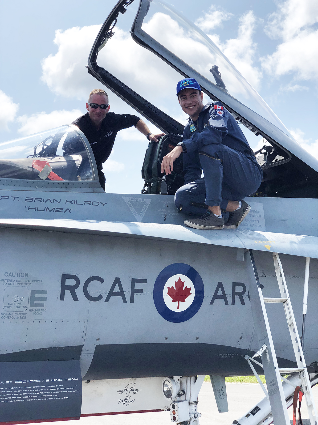 L’adjudant de première classe Nicholas Lourens (à droite) et le caporal-chef Mike Williams s’accroupissent sur les ailes opposées du Hornet de démonstration des Forces armées canadiennes de 2019. PHOTO : Lieutenant Becky Major