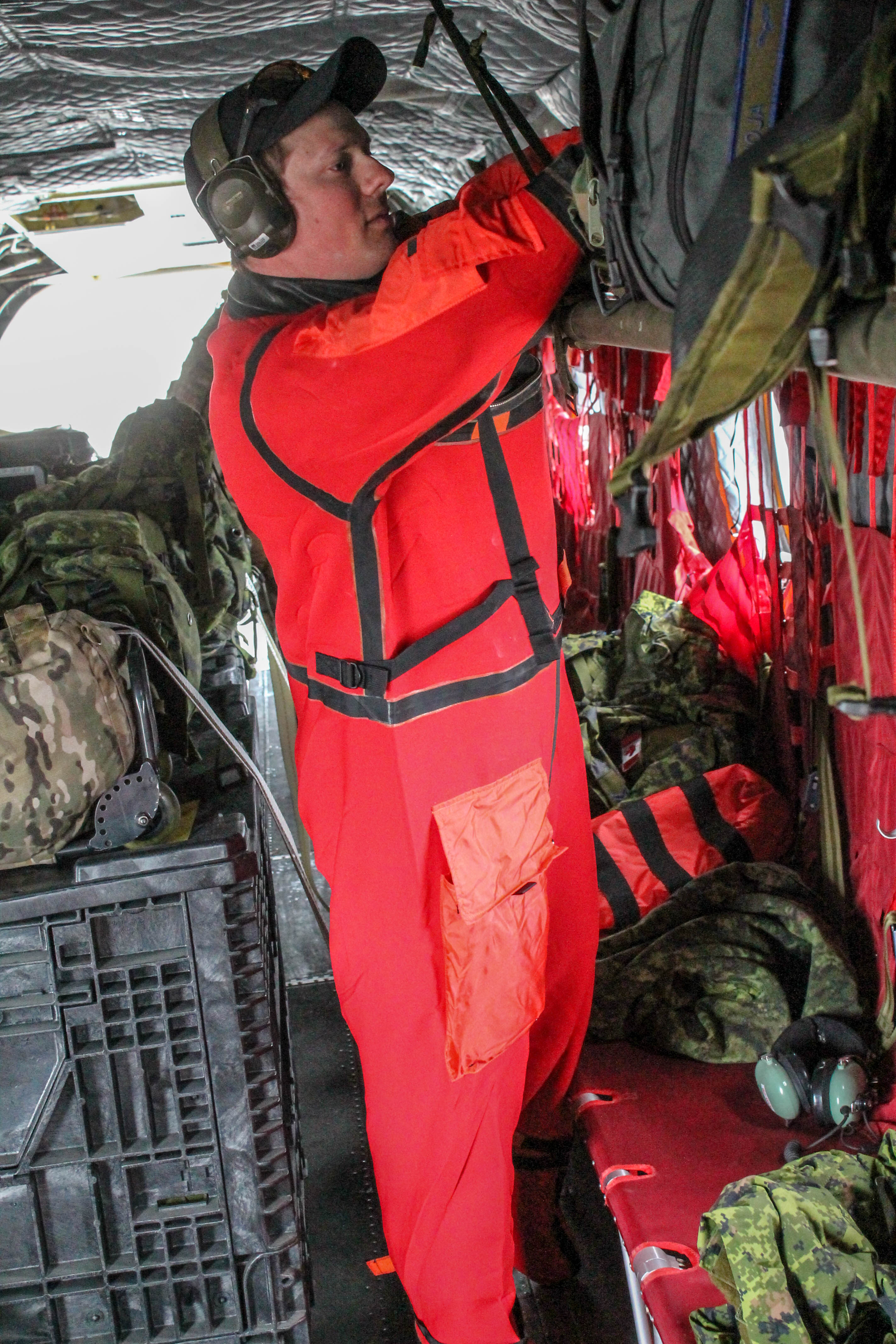 Le caporal Christopher Andrew, technicien en systèmes avioniques, revêt sa combinaison étanche avant de voler au-dessus de l’eau. PHOTO : Caporal Justin Critchley