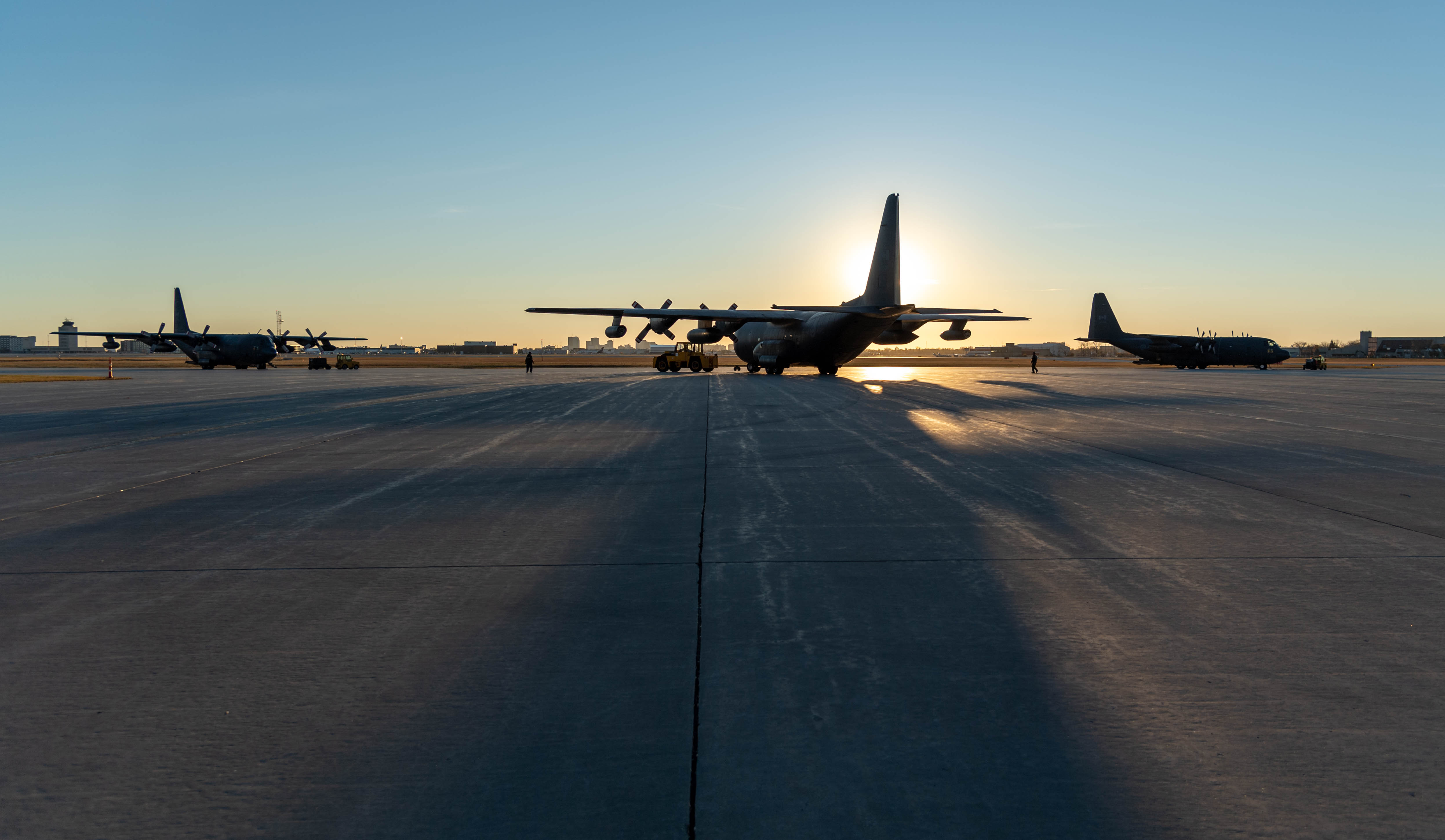 Des avions CC-130 Hercules se trouvent sur la piste à la 17e Escadre Winnipeg, au Manitoba, à l’aube, le 13 octobre 2020 avant de décoller afin de survoler Winnipeg pour marquer la 60e année de service de l’aéronef dans l’Aviation royale canadienne. PHOTO : Caporal Darryl Hepner