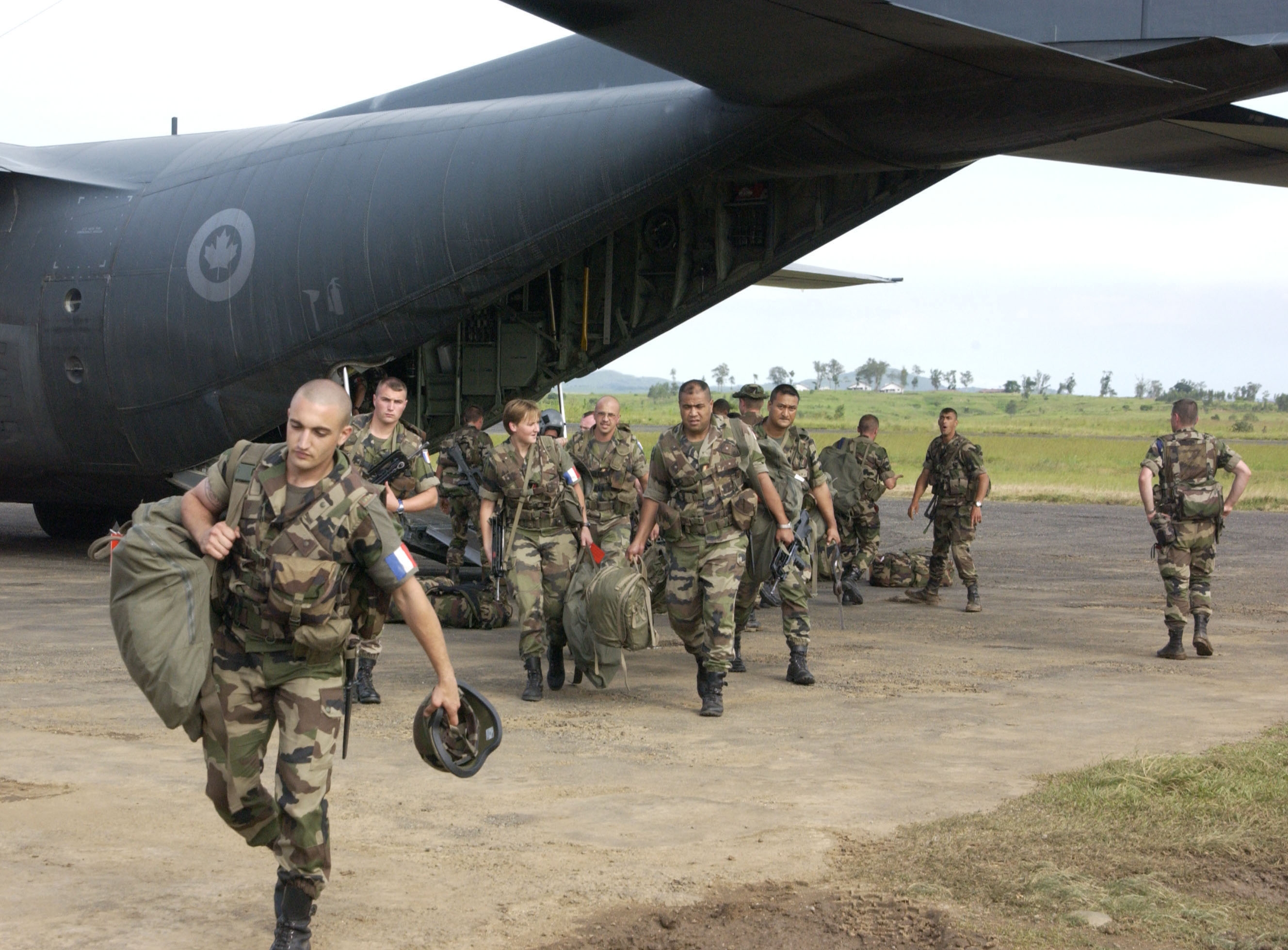 French soldiers disembark a Canadian CC-130 Hercules transport aircraft in Bunia, Democratic Republic of Congo, on June 11, 2003. The Canadian Forces supplied two CC-130 aircraft as part of Operation Caravan to help deploy the French-led coalition of approximately 1,400 troops into the war-torn country. PHOTO: Master Corporal Brian Walsh, IS2003-0327 