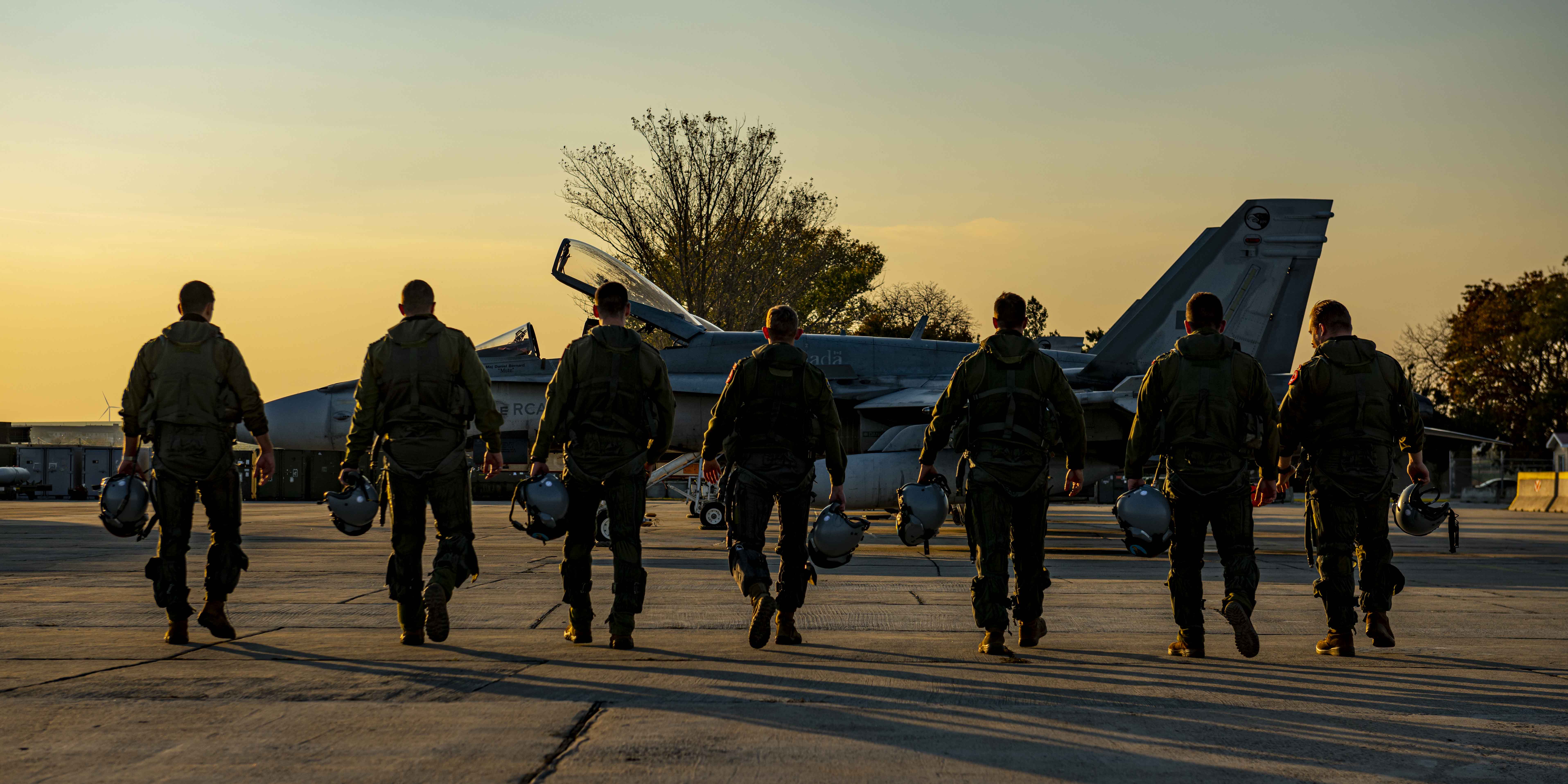 Des pilotes du 409e Escadron d’appui tactique marchent vers un chasseur Hornet CF188 de l’Aviation royale canadienne à la base aérienne Mihail Kogalniceanu avec la Force opérationnelle aérienne de l’opération REASSURANCE – Roumanie le 28 octobre 2021