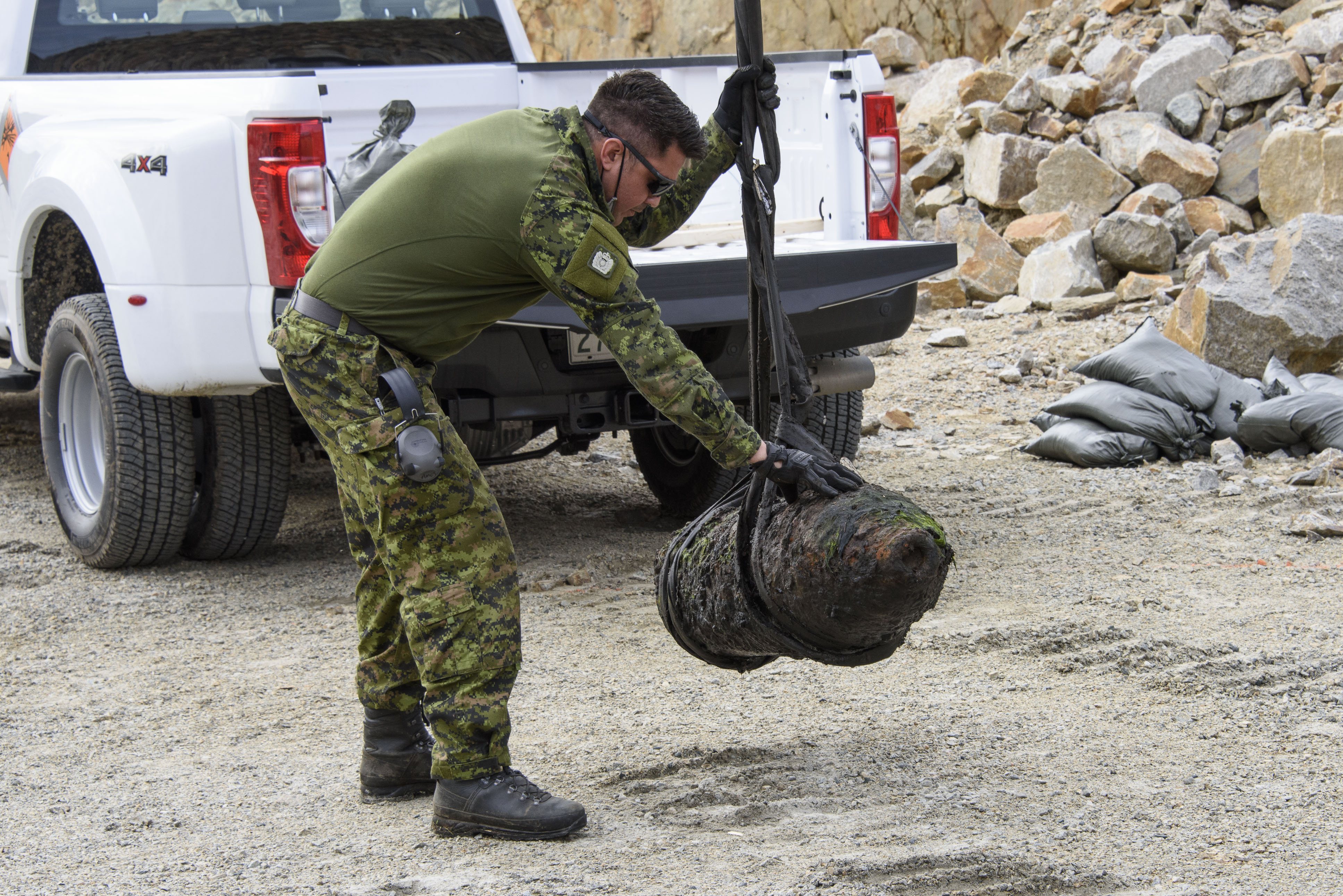 PO2 Tom Amos guides the UXO to its final position at the disposal site.