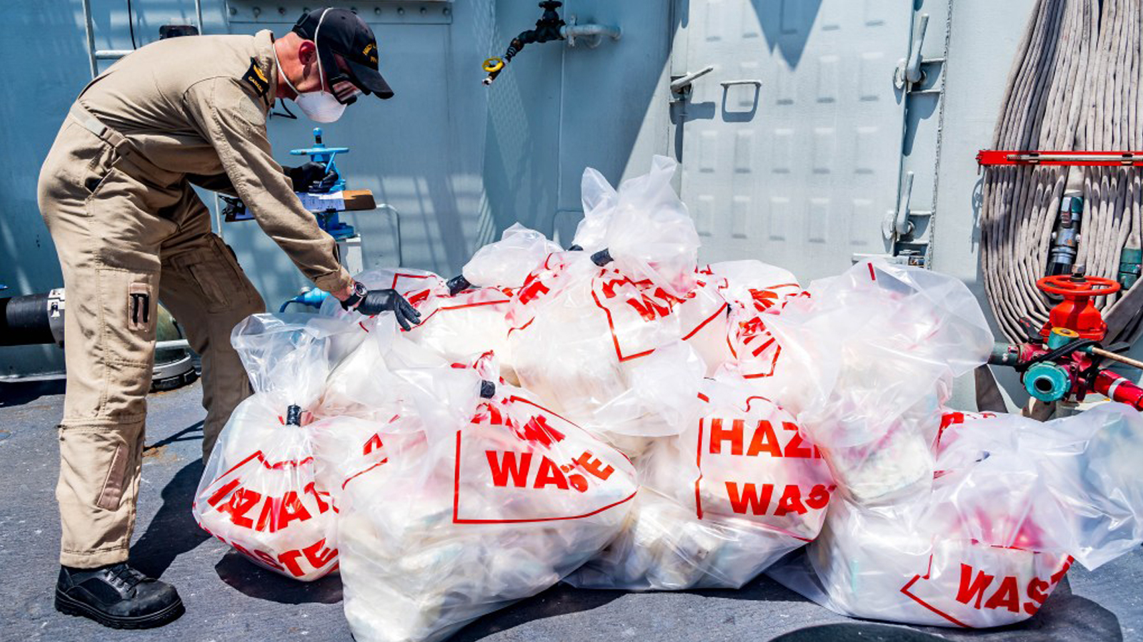 Slide - A Naval Boarding Party member works to sort and count contraband.