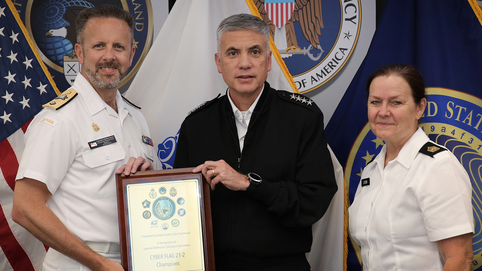 Cmdre Matthew Bowen, accepts a plaque from U.S. Army General Paul M. Nakasone