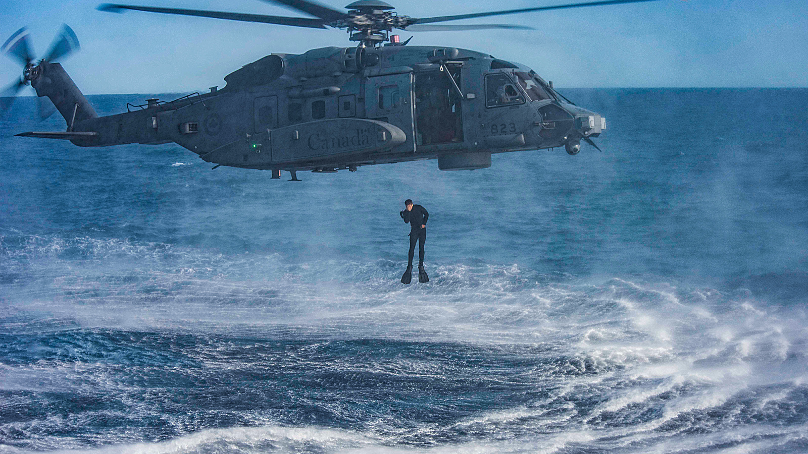 A diver from HMCS Toronto jumps from Royal Canadian Air Force CH-148 Cyclone