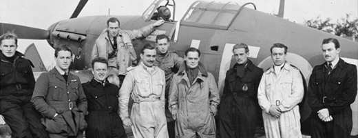Groupe de pilotes de la Seconde Guerre mondiale posant devant un avion
