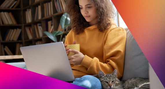 a woman looking at her laptop holding a mug