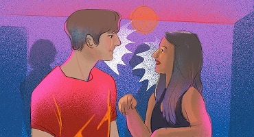 A man and woman standing close together at a party, smiling and making eye contact while engaging in a flirtatious conversation