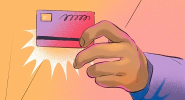 A hand holding a debit card, with a bright burst effect behind it.
