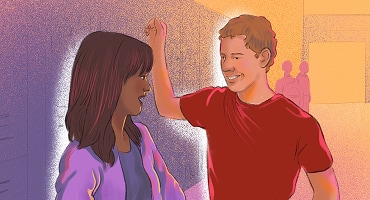 A man and woman standing close together and smiling, with the man leaning slightly toward her in a flirty manner.