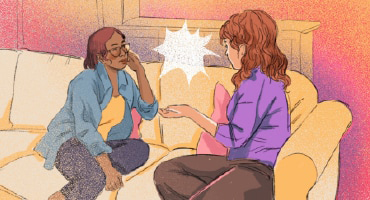 Two friends sitting on a couch talking