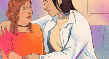 Two women sitting. One woman’s arm is around the other